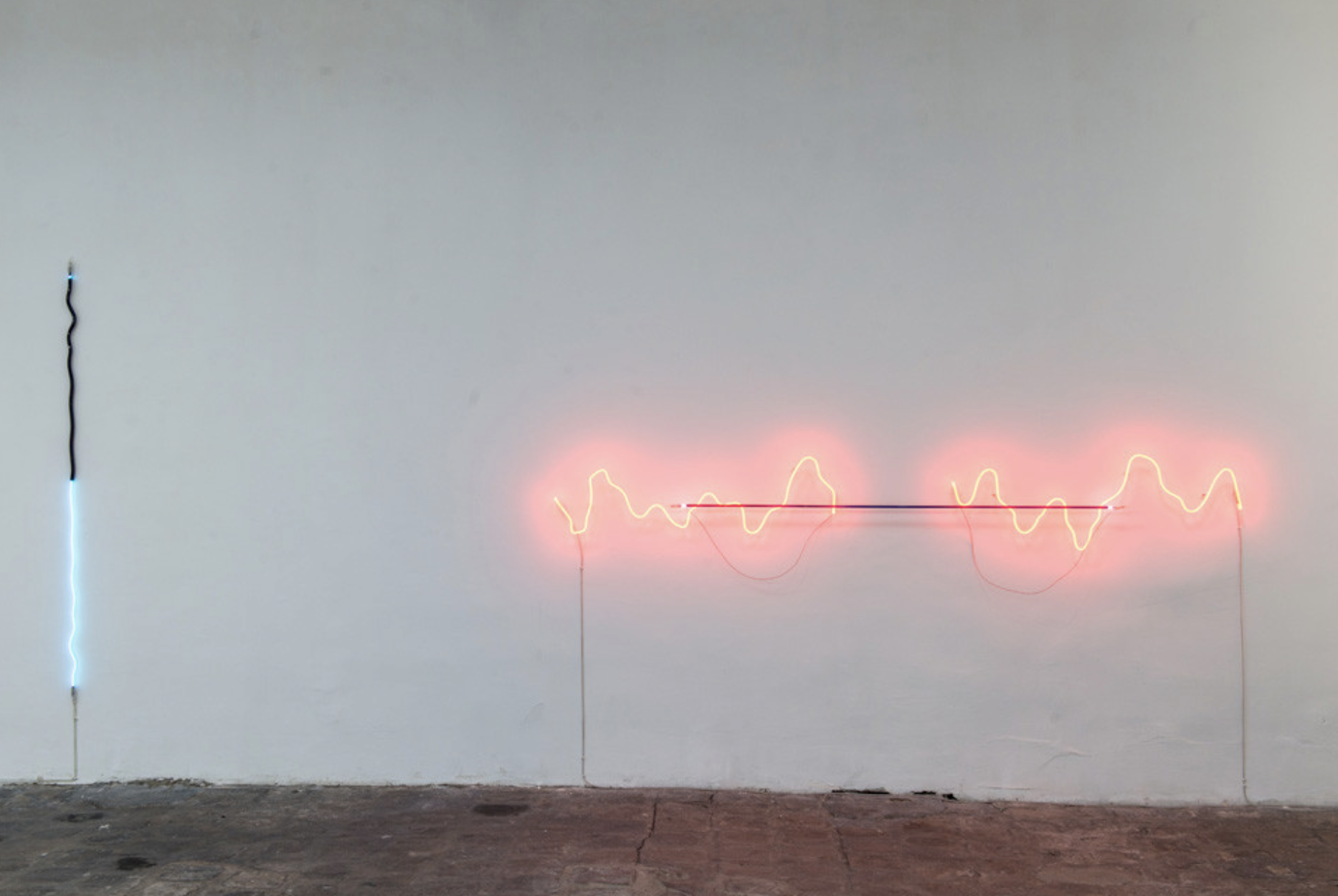 Jan van Munster, à gauche, « Between Plus and Minus », 2012, Argon, verre bleu et noir, transformateur,190 cm.    à droite, « Brainwave (Ratio) », 2008, Néon, verre rouge et noir, transformateur, 280 cm. Courtesy de l’artiste.