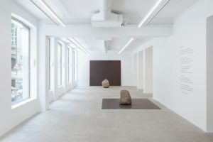 Vue de l'exposition Lee Ufan h-galerie Kamel Mennour. Pierre sur le sol d'une galerie.