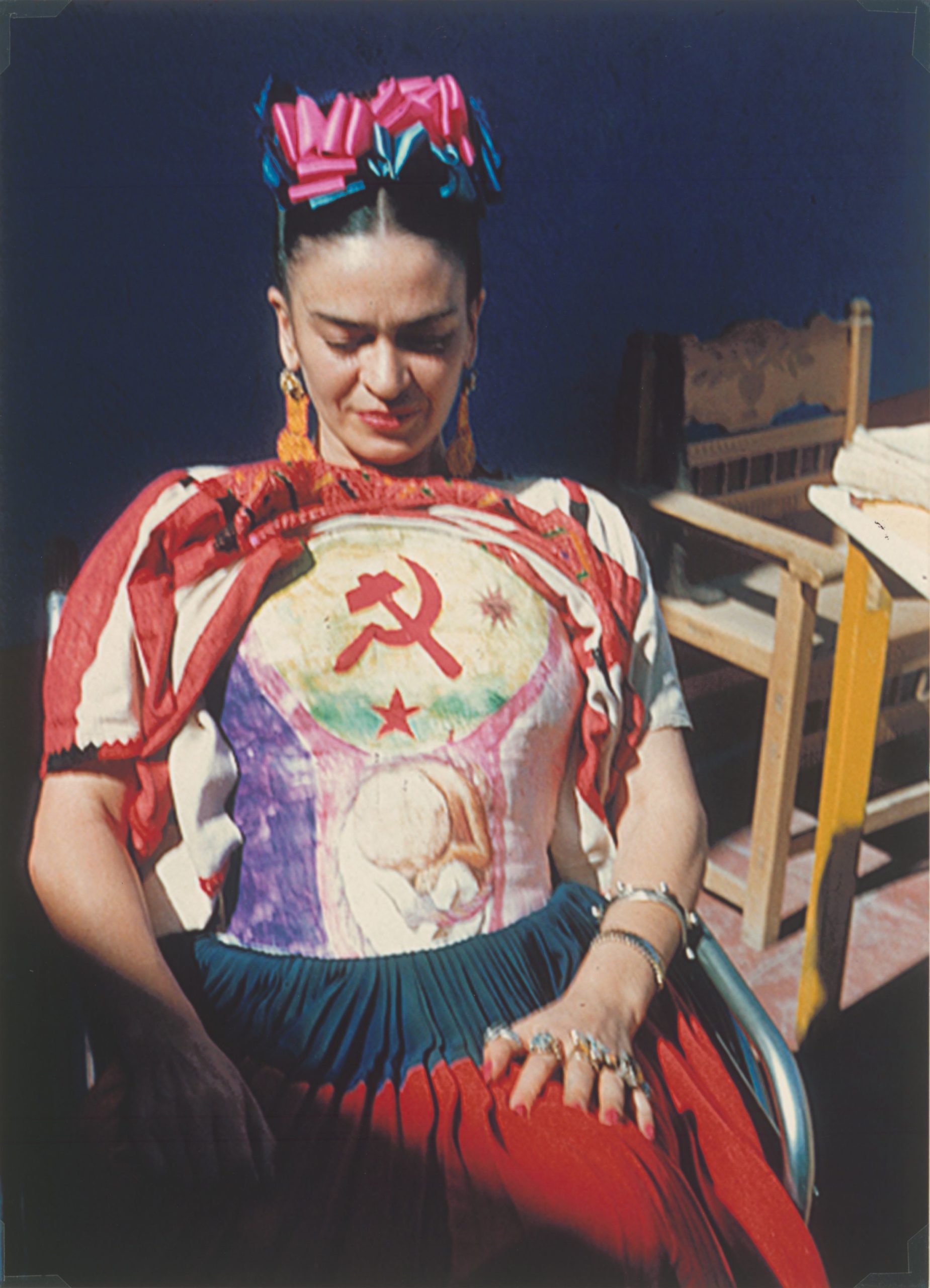 portrait photo artiste en costume mexicain coloré. Femme artiste assise avec des fleurs dans les cheveux.