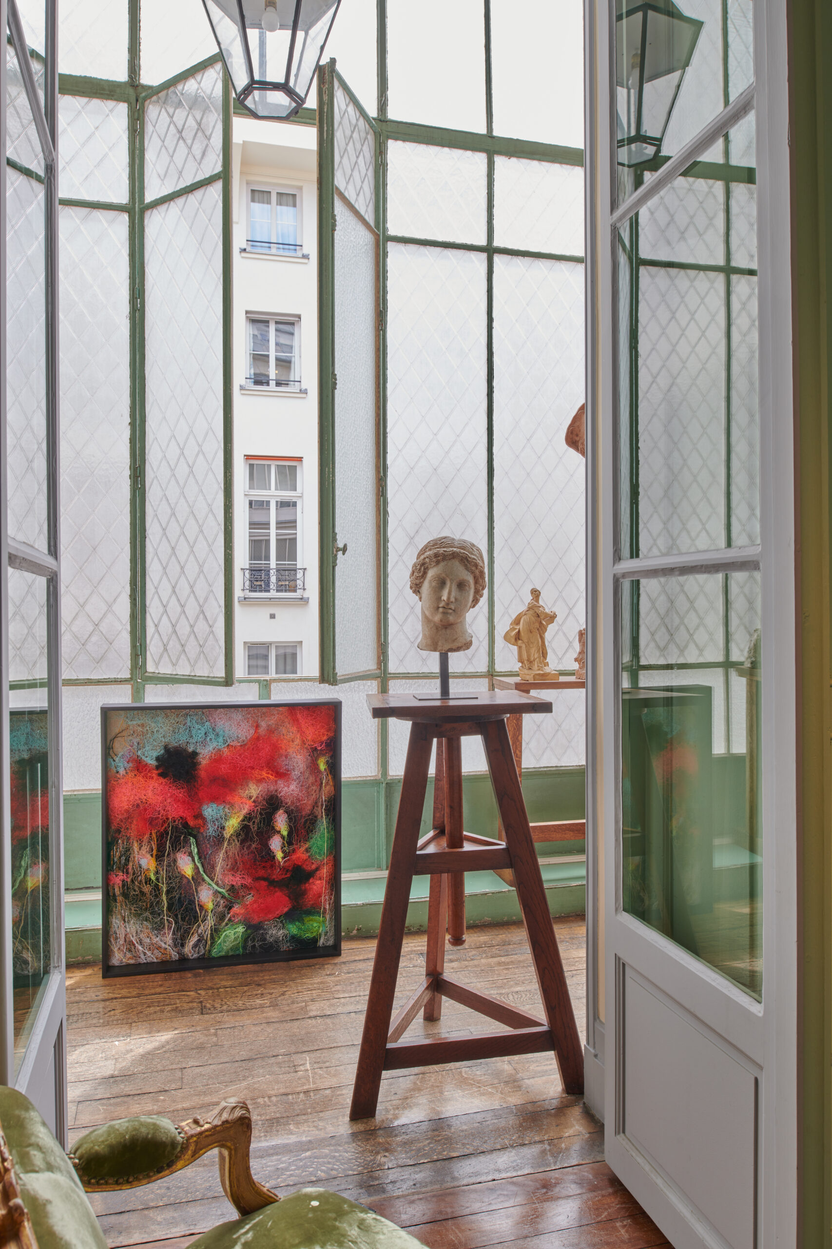 Galerie d'art ancien de Louis de Bayser. Atelier avec une verrière et une sculpture posée sur un tabouret.
